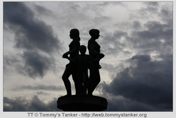 De tre på sokkel med mørke skyer rundt seg. Foto: TT.